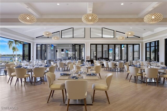 dining room featuring beam ceiling, light wood-type flooring, high vaulted ceiling, and a notable chandelier