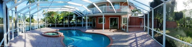 view of swimming pool with an in ground hot tub, a patio area, and a lanai