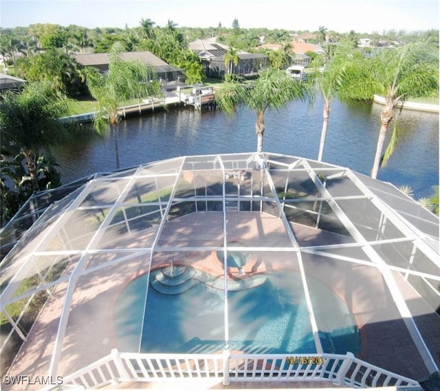 view of dock with a water view, glass enclosure, and a pool with hot tub