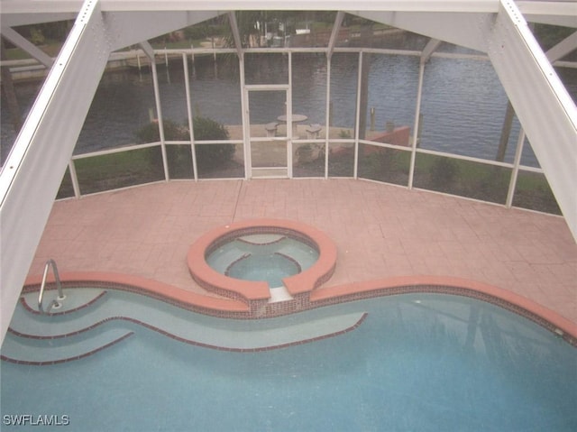 view of swimming pool with an in ground hot tub, a patio, a water view, and glass enclosure