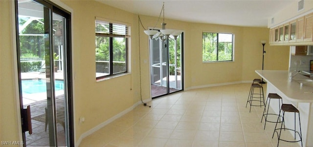 interior space featuring a wealth of natural light, light tile patterned flooring, and an inviting chandelier