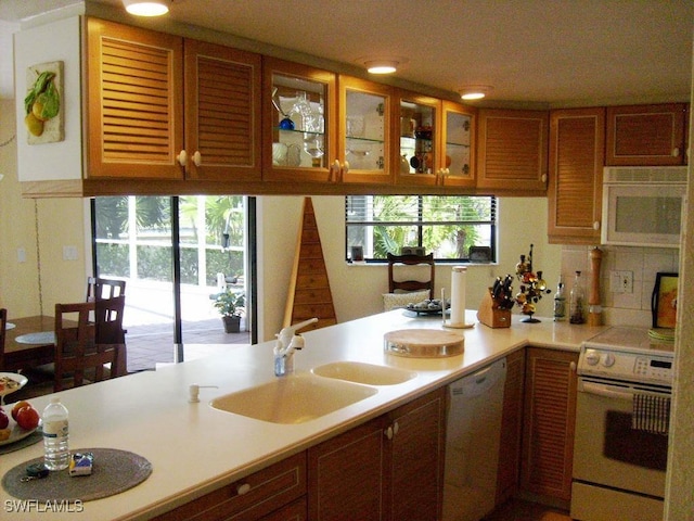 kitchen with white appliances, a healthy amount of sunlight, and sink