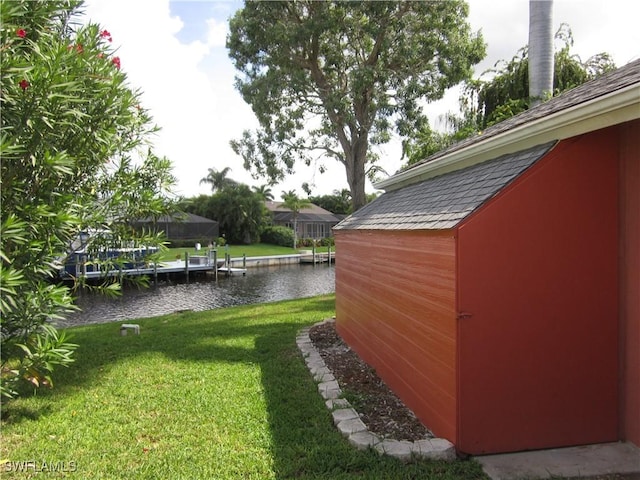 view of yard featuring a water view and a dock