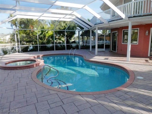 view of swimming pool featuring glass enclosure, an in ground hot tub, and a patio