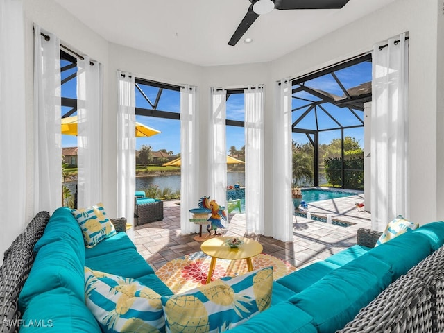 sunroom featuring ceiling fan and a water view