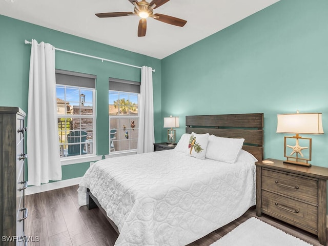 bedroom featuring ceiling fan, baseboards, and wood finished floors