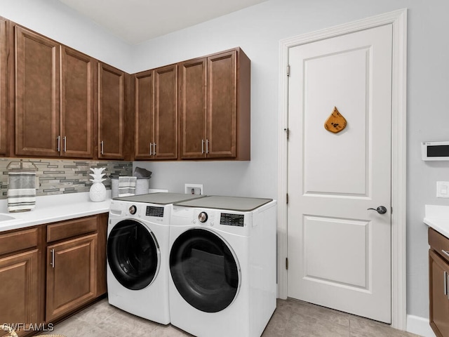 washroom with cabinet space, light tile patterned floors, and separate washer and dryer