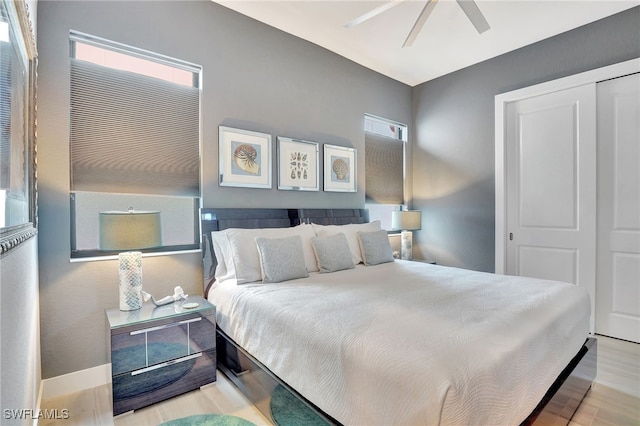 bedroom featuring ceiling fan, light hardwood / wood-style floors, and a closet