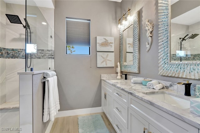 bathroom with vanity, hardwood / wood-style floors, and a tile shower