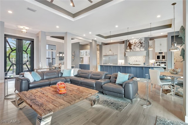 living room featuring light hardwood / wood-style floors and a raised ceiling