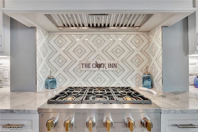 kitchen featuring light stone counters, backsplash, range, and premium range hood