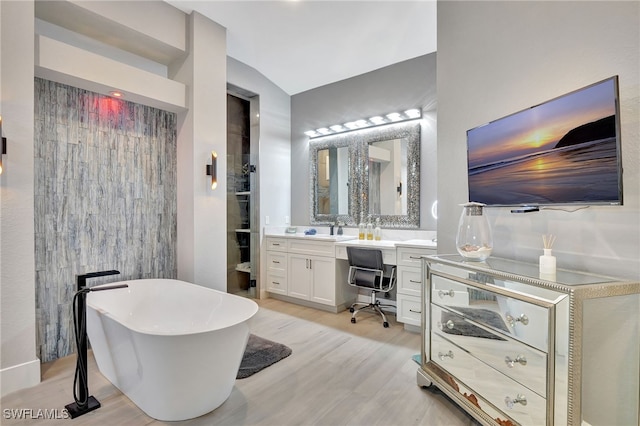 bathroom featuring vanity, hardwood / wood-style flooring, and a tub