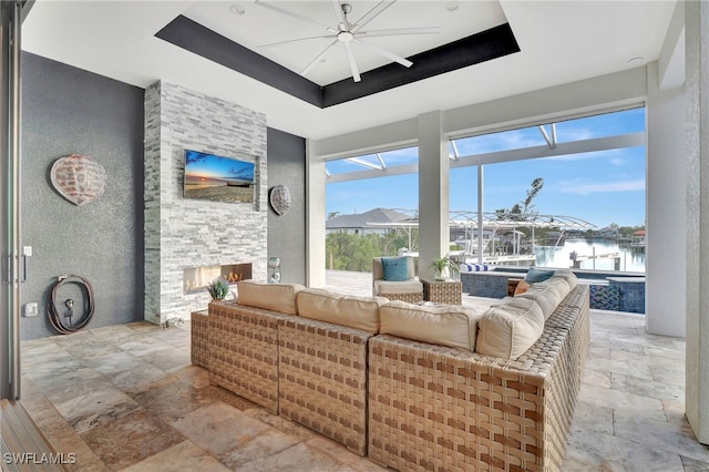 living room with a fireplace and a raised ceiling