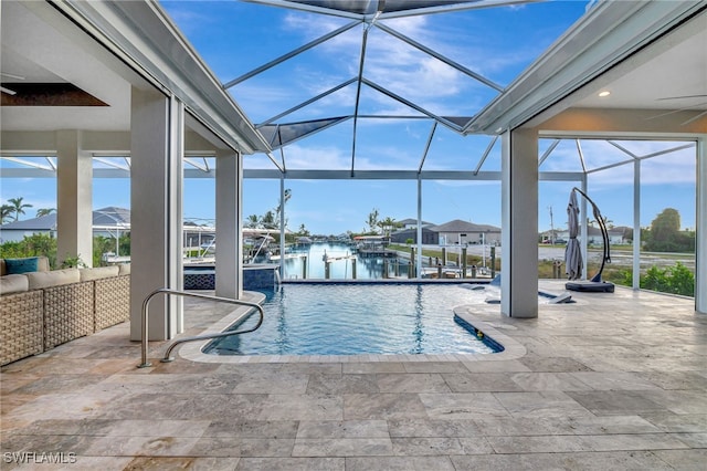 view of swimming pool featuring pool water feature, a water view, a lanai, ceiling fan, and a patio