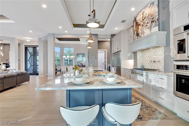 kitchen featuring a spacious island, appliances with stainless steel finishes, sink, and hanging light fixtures