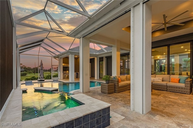 pool at dusk featuring outdoor lounge area, ceiling fan, a lanai, and a patio