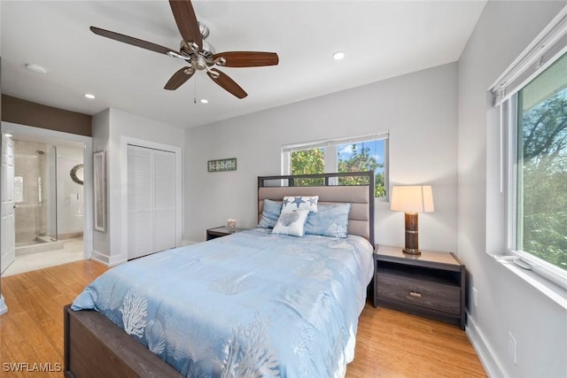 bedroom with a closet, light hardwood / wood-style floors, ensuite bath, and ceiling fan