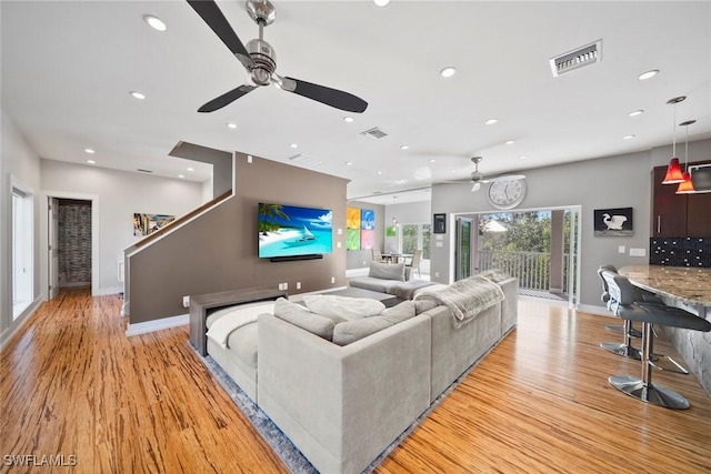 living room with ceiling fan and light wood-type flooring