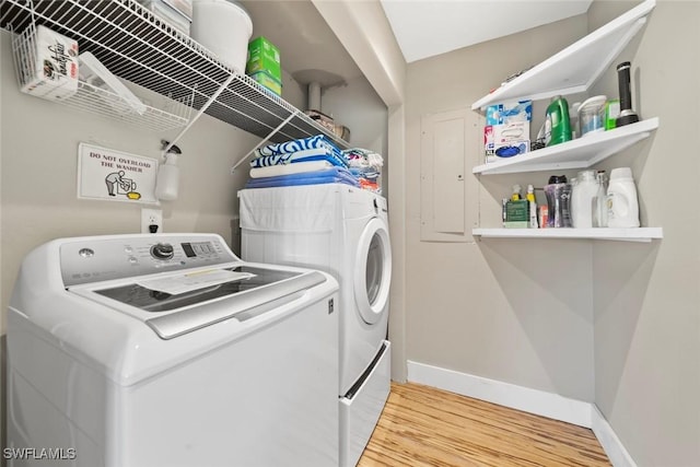 clothes washing area featuring hardwood / wood-style floors and washer and dryer