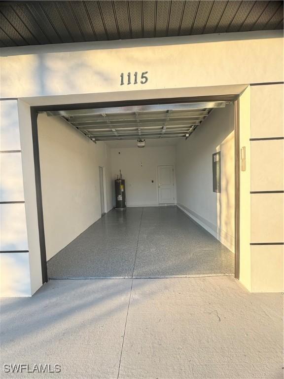 1115 Cumming St E, Lehigh Acres, FL 33974 - garage with water heater and a garage door opener