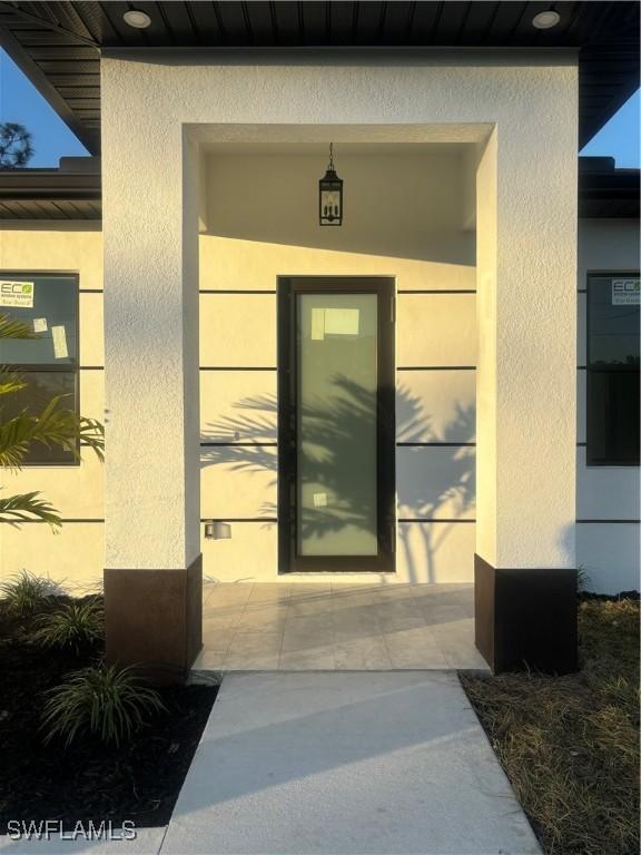 1115 Cumming St E, Lehigh Acres, FL 33974 - property entrance with stucco siding