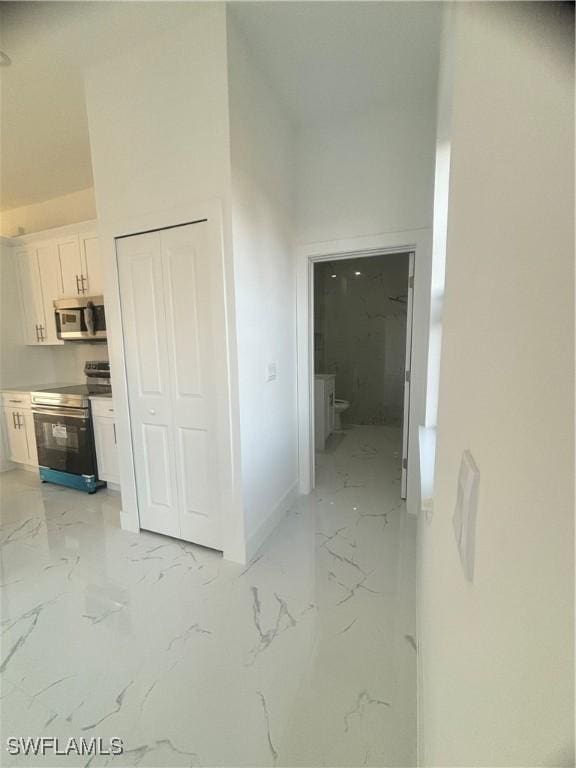 1115 Cumming St E, Lehigh Acres, FL 33974 - corridor with light marble finish floors and baseboards