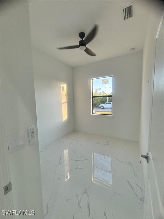 1115 Cumming St E, Lehigh Acres, FL 33974 - spare room with marble finish floors and ceiling fan