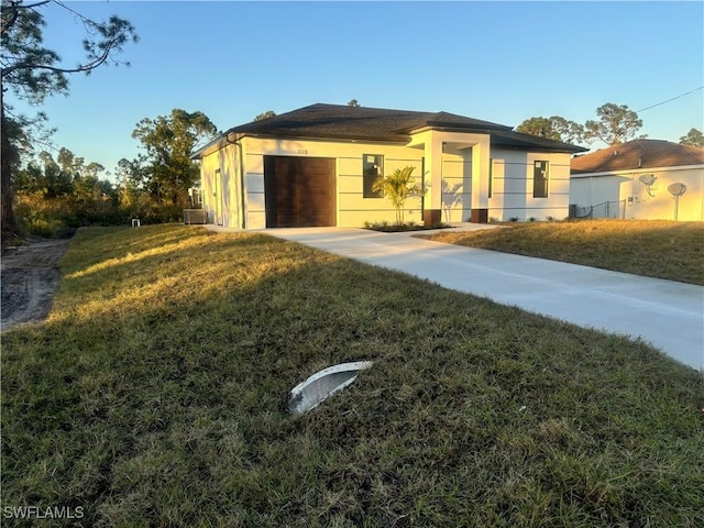 view of front of home with a garage, a front lawn, and central air condition unit