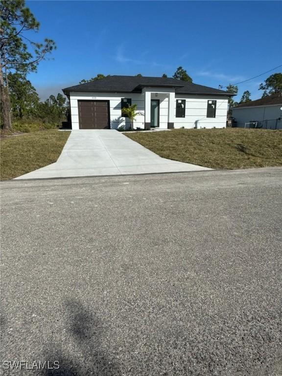 view of front of property with a front lawn and a garage