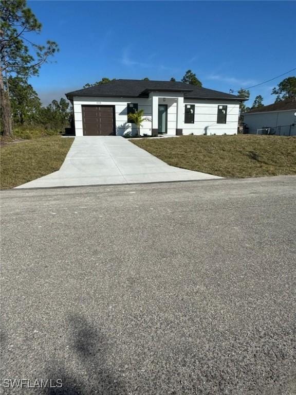view of front of home with a front yard, driveway, and an attached garage