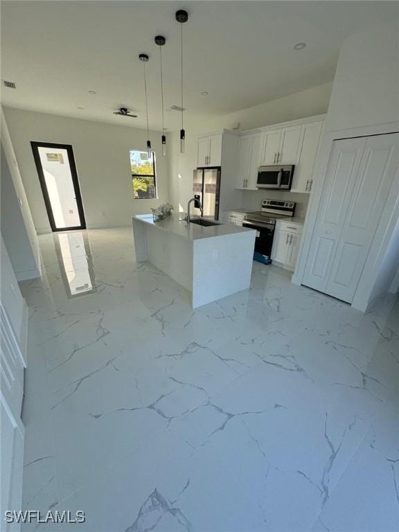 1115 Cumming St E, Lehigh Acres, FL 33974 - kitchen with stainless steel appliances, light marble finish flooring, white cabinetry, and hanging light fixtures