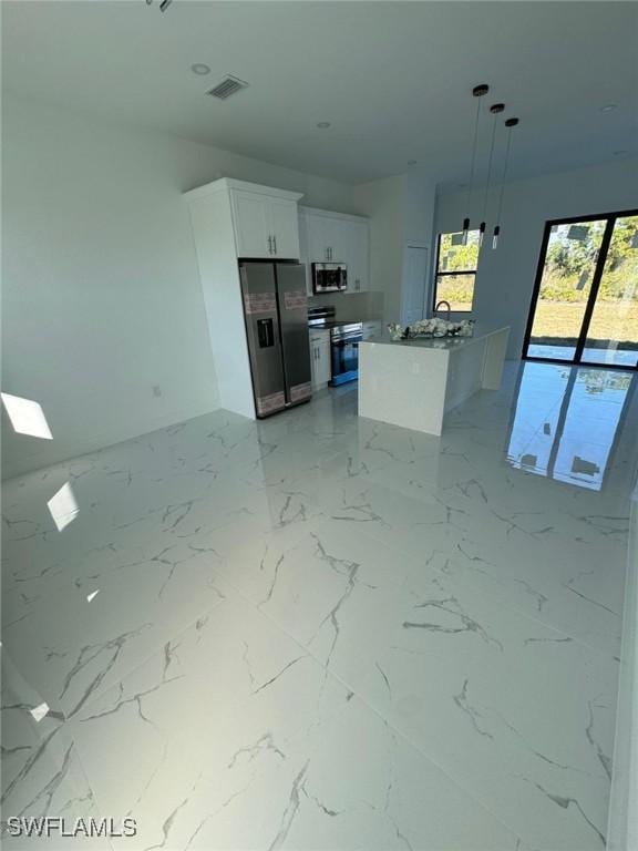 1115 Cumming St E, Lehigh Acres, FL 33974 - kitchen with stainless steel appliances, white cabinetry, hanging light fixtures, and a center island