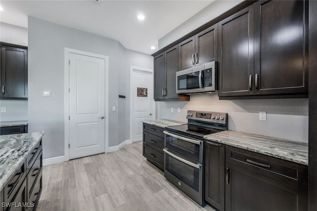 kitchen with stainless steel appliances, light stone countertops, dark brown cabinets, and light hardwood / wood-style flooring