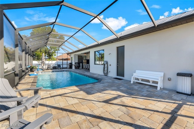 view of swimming pool with glass enclosure and a patio area