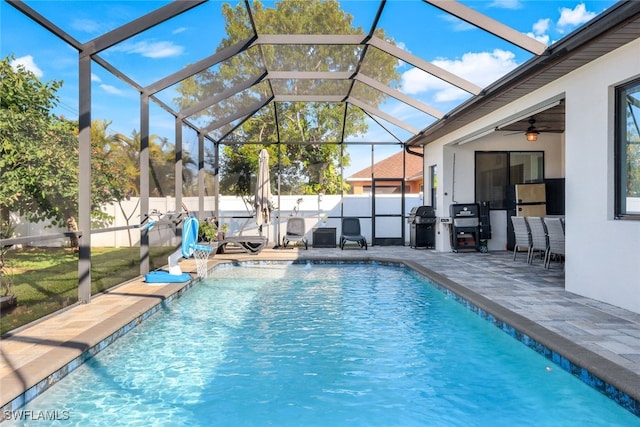 view of swimming pool with a patio, a grill, a lanai, pool water feature, and ceiling fan