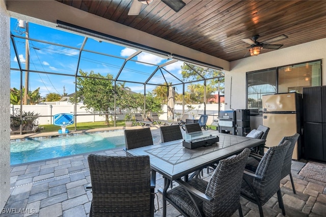 view of patio / terrace with pool water feature, ceiling fan, a lanai, and a fenced in pool