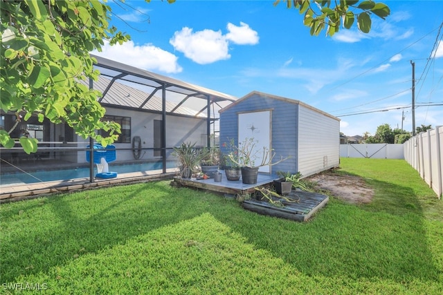 back of house featuring a lanai, a yard, a swimming pool, and a shed