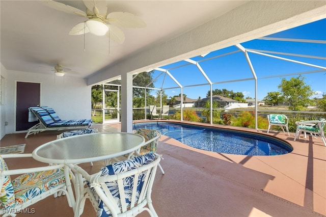 view of pool with ceiling fan, a patio area, and glass enclosure