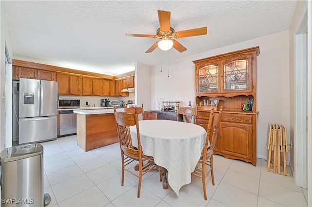 dining room with ceiling fan, light tile patterned flooring, and a textured ceiling