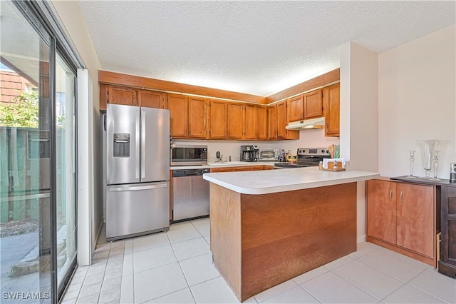 kitchen with kitchen peninsula, light tile patterned floors, a textured ceiling, and appliances with stainless steel finishes