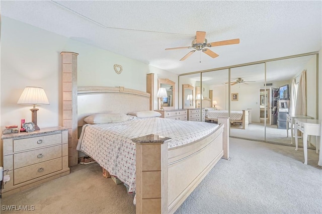 carpeted bedroom with ceiling fan, a closet, and a textured ceiling