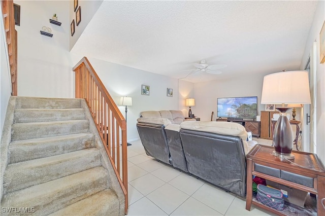 living room featuring a textured ceiling, ceiling fan, and light tile patterned flooring