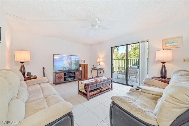 living room featuring ceiling fan, light tile patterned floors, and a textured ceiling