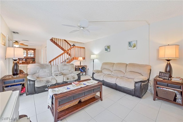 tiled living room with a textured ceiling and ceiling fan