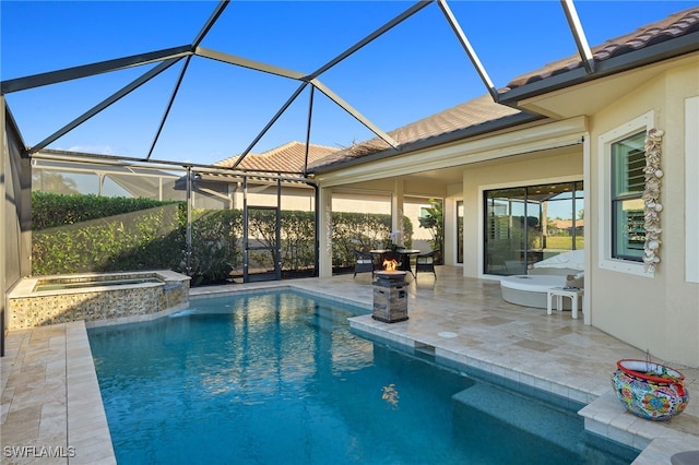 view of pool featuring an in ground hot tub, glass enclosure, and a patio area