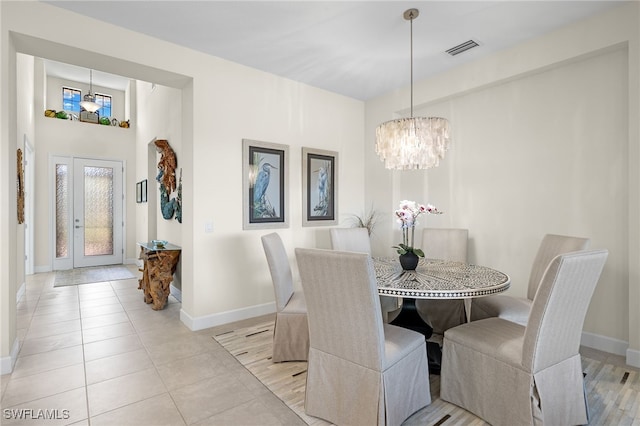 tiled dining room with a notable chandelier