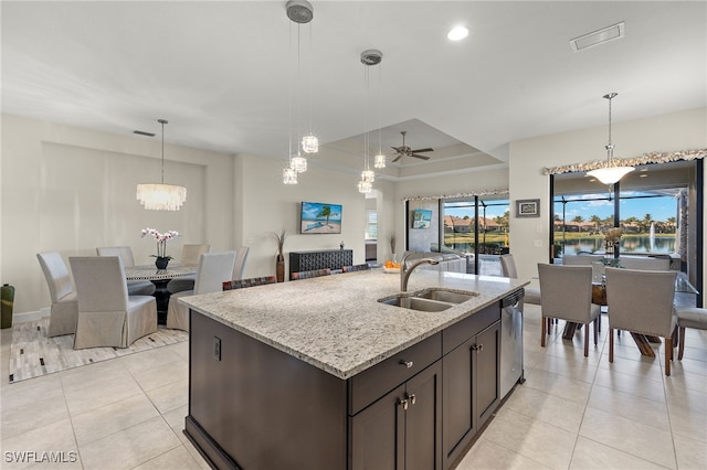 kitchen featuring sink, light stone counters, stainless steel dishwasher, decorative light fixtures, and ceiling fan with notable chandelier