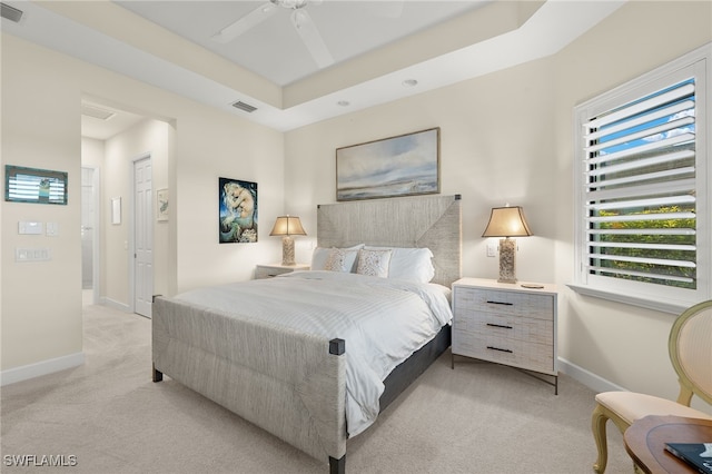 carpeted bedroom featuring a closet, a raised ceiling, and ceiling fan