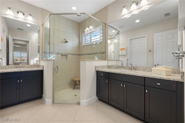 bathroom featuring tile patterned floors, vanity, a healthy amount of sunlight, and an enclosed shower