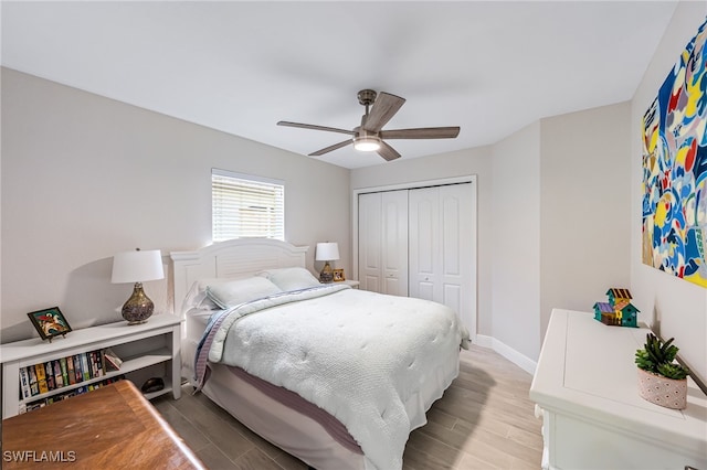 bedroom with ceiling fan, a closet, and light hardwood / wood-style floors